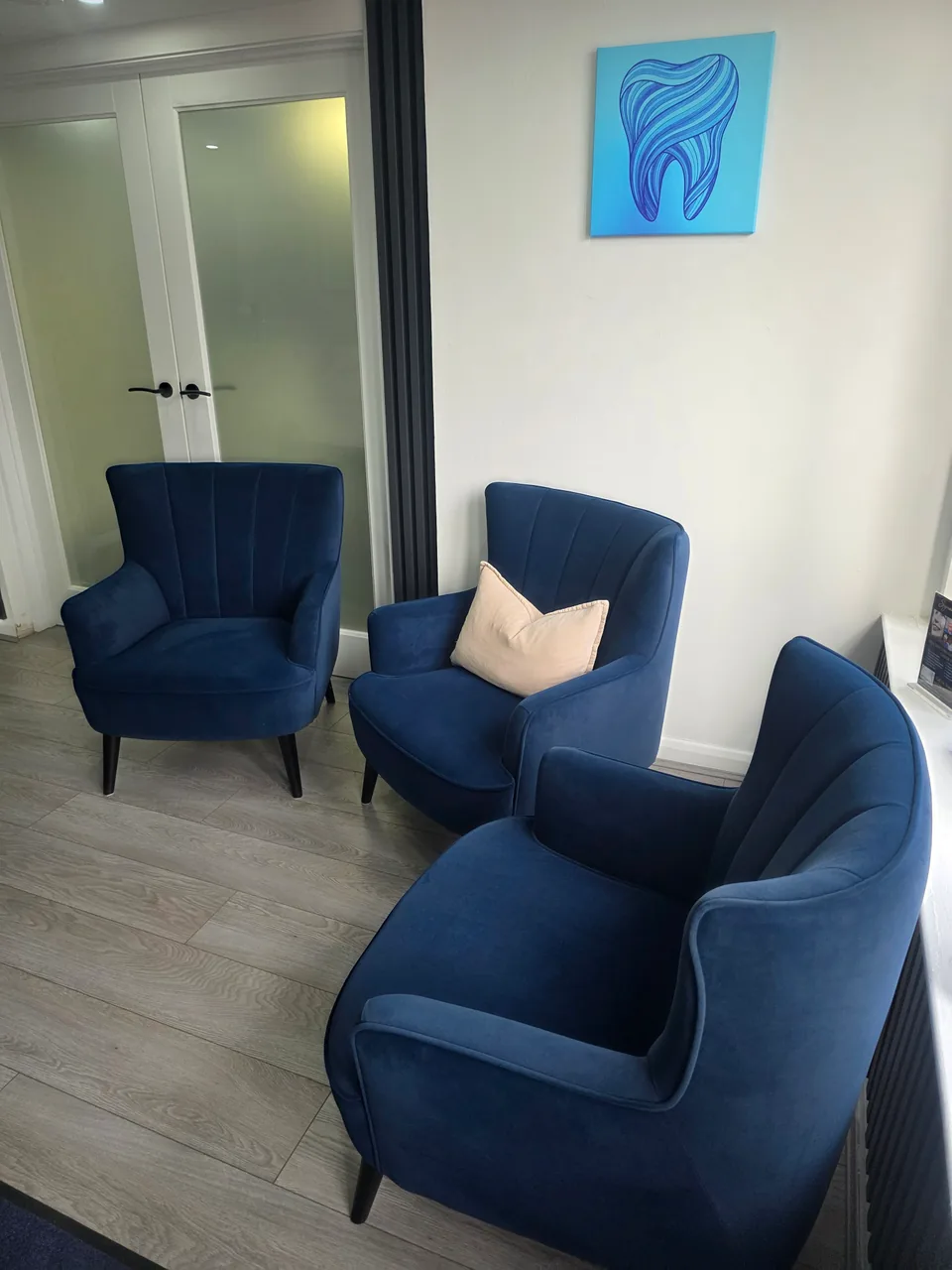 Comfortable blue chairs in the Signature Dentures waiting room